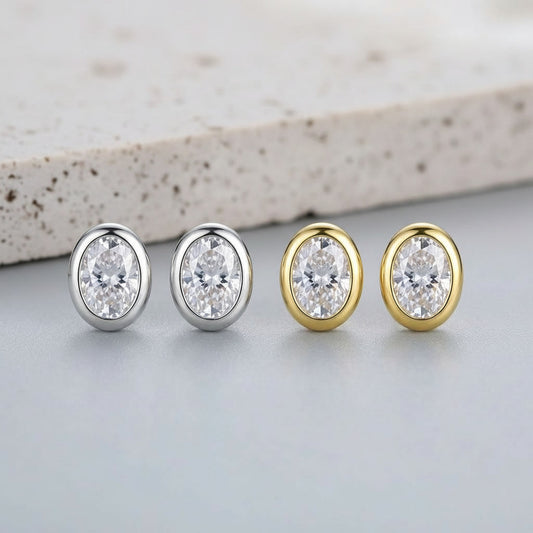 Four diamond stud earrings in gold and silver on a light background